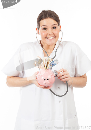 Image of happy woman doctor with piggy bank full of money