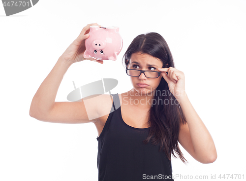 Image of Young woman worried with a piggy bank