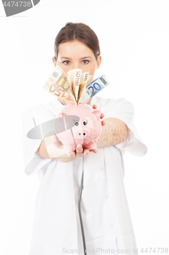 Image of A woman shows a piggy bank full of European banknotes