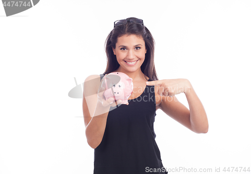 Image of Young woman with glasses happy with piggy bank