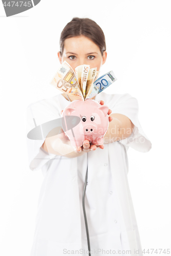 Image of A woman shows a piggy bank full of European banknotes