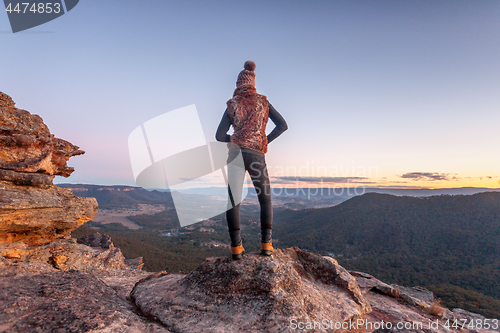 Image of Bushwalker on summit of mountain with valley views