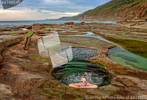 Image of Female enjoying Figure 8 Pools on coastal rock shelf