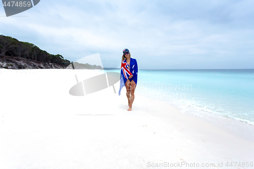 Image of Woman on beach with Aussie flag draped around her