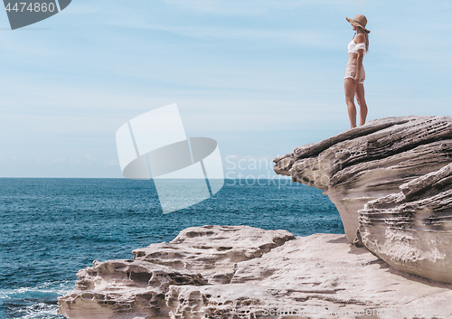 Image of Fashion woman enjoying the summer sun by the coast