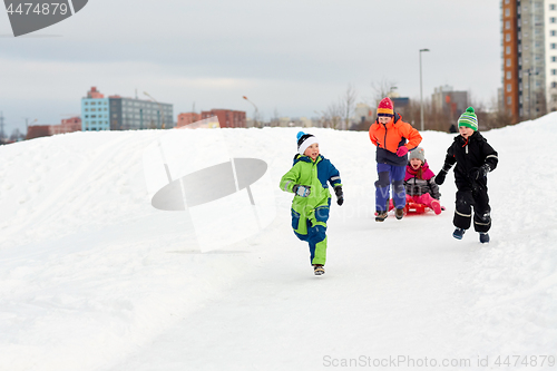 Image of happy kids with sled having fun outdoors in winter