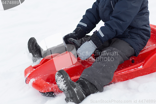Image of close up of boy driving sled in winter