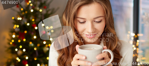 Image of happy woman with cup of tea or coffee on christmas