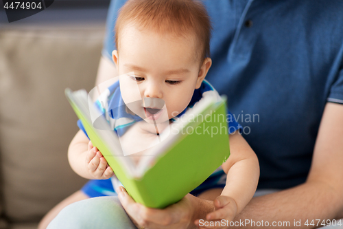 Image of close up of baby boy and father with book at home