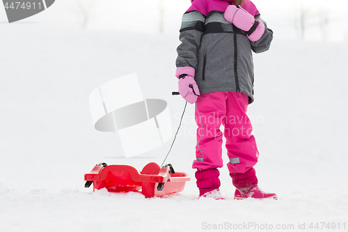 Image of little girl with sled outdoors in winter