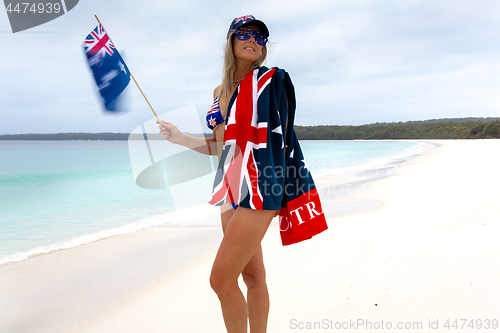Image of Woman waving Australian flag on beach