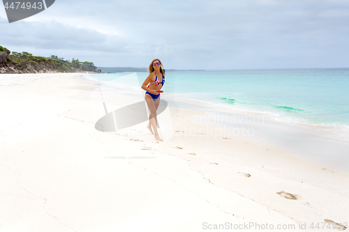 Image of Aussie woman playing frisbee on the beach