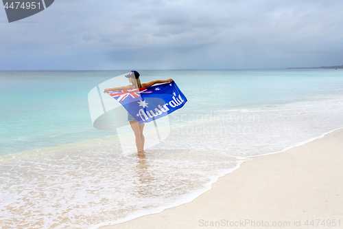 Image of Woman on beach holding Australian Flag, travel, tourism, Australia Day