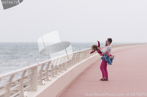 Image of mother and cute little girl on the promenade by the sea