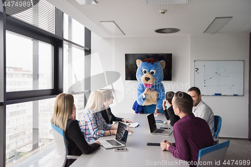 Image of boss dresed as bear having fun with business people in trendy of