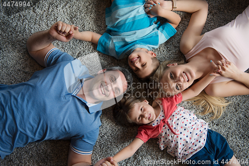 Image of happy family lying on the floor