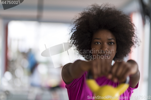 Image of woman working out in a crossfit gym with dumbbells