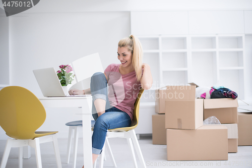 Image of Young woman moving in a new home