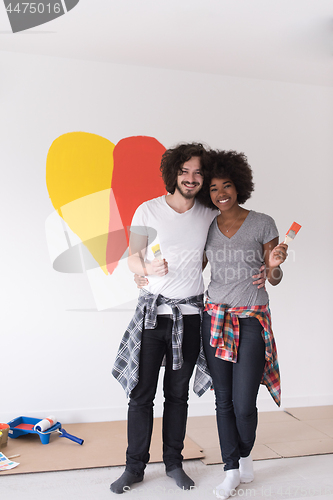 Image of couple with painted heart on wall