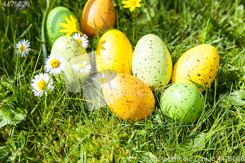 Image of colored Easter eggs hidden in flowers and grass