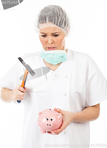 Image of a woman doctor breaks his piggy bank with a hammer