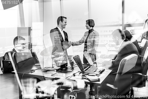 Image of Business people shaking hands in moder corporate office.