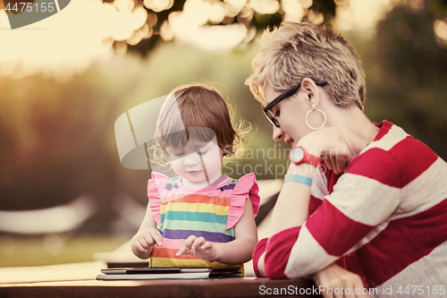 Image of mom and her little daughter using tablet computer