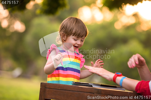 Image of mom and her little daughter using tablet computer