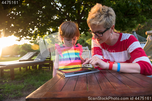 Image of mom and her little daughter using tablet computer