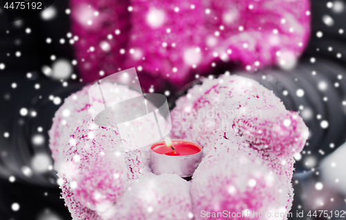 Image of close up of hands in winter mittens holding candle