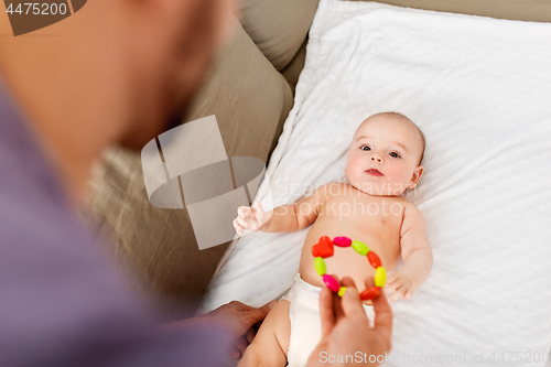 Image of close up of father and baby with rattle toy