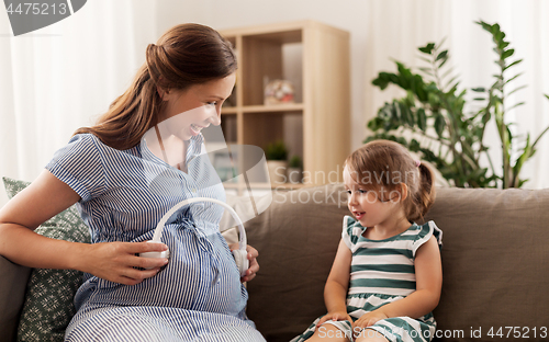 Image of pregnant mother and little girl with headphones