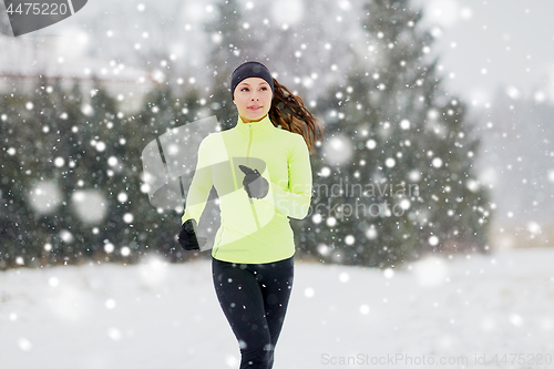 Image of happy woman running outdoors in winter