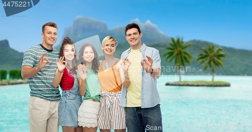 Image of happy friends showing ok hand sign over bora bora