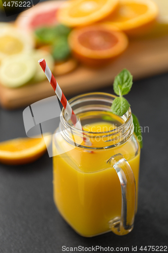 Image of mason jar glass of fruit juice on slate table top