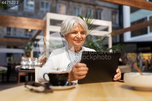 Image of senior woman with tablet pc and coffee at cafe