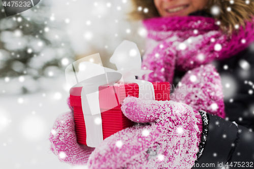 Image of close up of woman with christmas gift outdoors