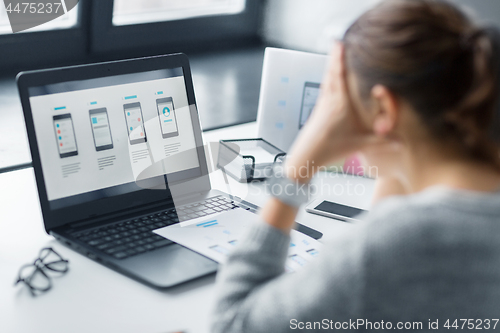 Image of stressed designer with user interface on laptop