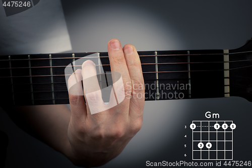 Image of Guitar chord on a dark background. G Minor Chord. Gm tab fingering