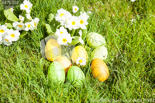 Image of colored Easter eggs hidden in flowers and grass