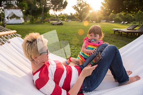 Image of mom and a little daughter relaxing in a hammock