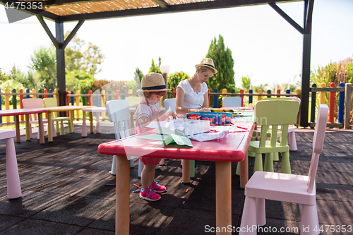 Image of mom and little daughter drawing a colorful pictures