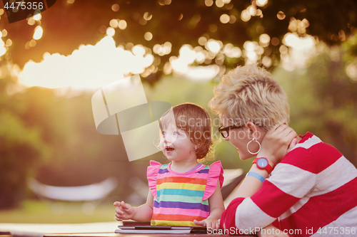 Image of mom and her little daughter using tablet computer