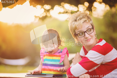 Image of mom and her little daughter using tablet computer