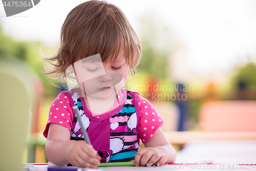 Image of little girl drawing a colorful pictures