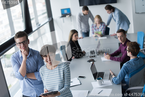 Image of Two Business People Working With Tablet in office