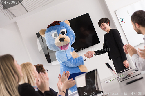 Image of boss dresed as bear having fun with business people in trendy of