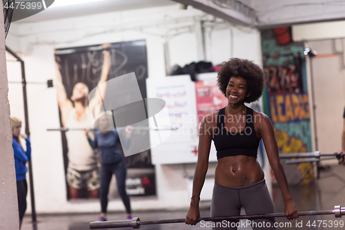 Image of black woman lifting empty bar