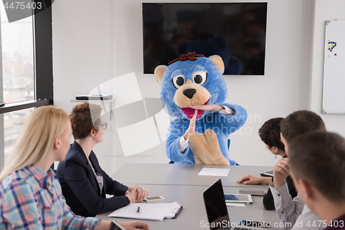 Image of boss dresed as bear having fun with business people in trendy of