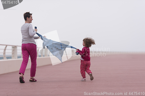 Image of mother and cute little girl on the promenade by the sea